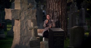 Movie still from “Harold and Maude” (1971), directed by Hal Ashby – A woman sitting on a bench in a cemetery; Wide shot, High angle
