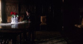 Movie still from “Harold and Maude” (1971), directed by Hal Ashby – A man sitting at a table with a rose in front of him; Wide shot, High angle