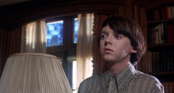 Movie still from “Harold and Maude” (1971), directed by Hal Ashby – A man standing in front of a lamp in front of a window; Close Up shot, Low angle