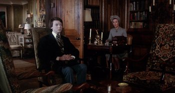 Movie still from “Harold and Maude” (1971), directed by Hal Ashby – A man and a woman sitting at a table in a room; Medium shot, High angle
