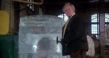Movie still from “Harold and Maude” (1971), directed by Hal Ashby – An older man holding an axe in front of an ice sculpture; Medium shot, Low angle