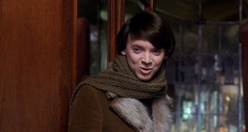 Movie still from “Harold and Maude” (1971), directed by Hal Ashby – A young man wearing a brown jacket and a scarf; Close Up shot, Over the shoulder angle