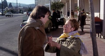 Movie still from “Harold and Maude” (1971), directed by Hal Ashby – Two women are talking on the sidewalk of a city street; Medium shot, Low angle