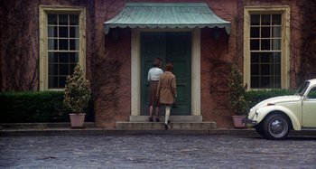 Movie still from “Harold and Maude” (1971), directed by Hal Ashby – A couple of people that are standing in front of a door; Wide shot, Low angle