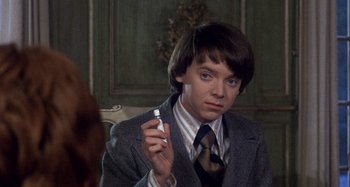Movie still from “Harold and Maude” (1971), directed by Hal Ashby – A young man in a suit and tie holding a spray bottle in his hand; Close Up shot, High angle