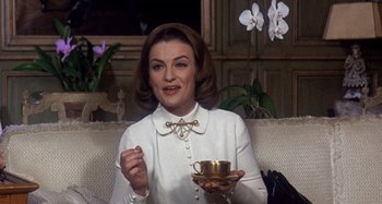 Movie still from “Harold and Maude” (1971), directed by Hal Ashby – A woman sitting on top of a couch holding a cup of coffee; Medium shot, Low angle