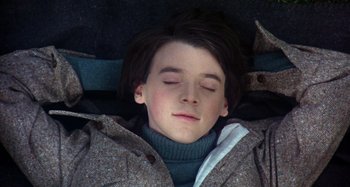 Movie still from “Harold and Maude” (1971), directed by Hal Ashby – A young boy is sleeping in the snow; Close Up shot, Overhead angle