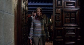 Movie still from “Harold and Maude” (1971), directed by Hal Ashby – A man and a woman standing in front of a doorway; Medium shot, Low angle