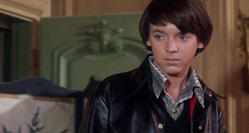 Movie still from “Harold and Maude” (1971), directed by Hal Ashby – A young man in a leather jacket looking at the camera; Close Up shot, Over the shoulder angle