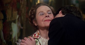 Movie still from “Harold and Maude” (1971), directed by Hal Ashby – An older woman hugging a young man in a room; Close Up shot, Over the shoulder angle