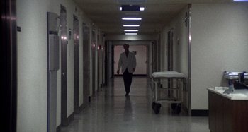 Movie still from “Harold and Maude” (1971), directed by Hal Ashby – A man walking down a hallway in a hospital; Wide shot, Low angle