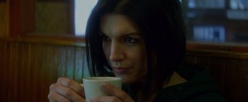 Movie still from “Haywire” (2011), directed by Steven Soderbergh – A person holding a coffee cup; Close Up shot, High angle