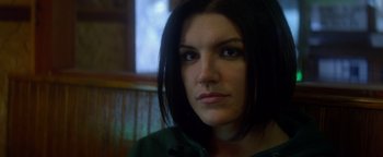 Movie still from “Haywire” (2011), directed by Steven Soderbergh – A person wearing a green shirt; Close Up shot, Over the shoulder angle