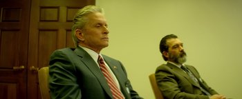 Movie still from “Haywire” (2011), directed by Steven Soderbergh – A man in a suit and tie sitting next to another man in a suit and tie; Medium shot, Over the shoulder angle