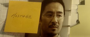 Movie still from “Haywire” (2011), directed by Steven Soderbergh – A person holding a yellow piece of paper; Extreme Close Up shot, High angle
