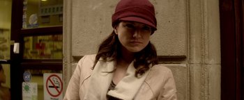 Movie still from “Haywire” (2011), directed by Steven Soderbergh – A woman wearing a red hat and a beige jacket; Close Up shot, Low angle
