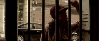 Movie still from “Haywire” (2011), directed by Steven Soderbergh – A woman wearing a hat standing in front of a window; Close Up shot, Low angle