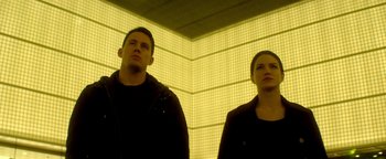 Movie still from “Haywire” (2011), directed by Steven Soderbergh – A man and a woman standing next to each other; Medium shot, Low angle