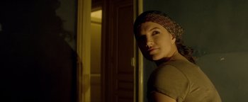 Movie still from “Haywire” (2011), directed by Steven Soderbergh – A woman wearing a head scarf in front of a door; Close Up shot, Over the shoulder angle