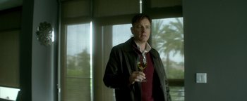 Movie still from “Haywire” (2011), directed by Steven Soderbergh – A man holding a glass of wine in his right hand; Medium shot, Low angle