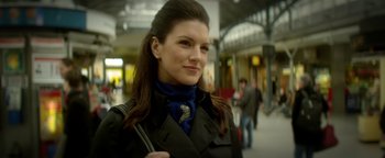 Movie still from “Haywire” (2011), directed by Steven Soderbergh – A beautiful woman with long dark brown hair wearing a black jacket; Close Up shot, Over the shoulder angle