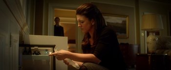 Movie still from “Haywire” (2011), directed by Steven Soderbergh – A woman sitting on the floor looking at something on the floor; Medium shot, Low angle