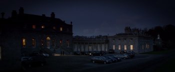 Movie still from “Haywire” (2011), directed by Steven Soderbergh – Cars are parked in a parking lot in front of a building at night; Extreme Wide shot, High angle