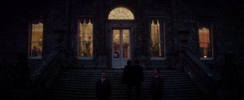 Movie still from “Haywire” (2011), directed by Steven Soderbergh – A group of men standing on the steps of a building; Extreme Wide shot, Low angle