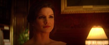 Movie still from “Haywire” (2011), directed by Steven Soderbergh – A beautiful woman in a dark room with a picture on the wall; Close Up shot, Over the shoulder angle