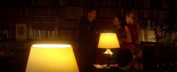 Movie still from “Haywire” (2011), directed by Steven Soderbergh – A man and a woman standing next to each other in a library; Medium shot, Over the shoulder angle