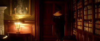 Movie still from “Haywire” (2011), directed by Steven Soderbergh – A woman standing in front of a wooden door; Medium shot, High angle