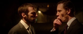 Movie still from “Haywire” (2011), directed by Steven Soderbergh – Two men in business suits are looking at each other; Close Up shot, Over the shoulder angle