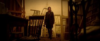 Movie still from “Haywire” (2011), directed by Steven Soderbergh – A woman standing in front of a pile of junk; Wide shot, Low angle