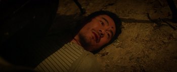 Movie still from “Haywire” (2011), directed by Steven Soderbergh – A man laying on the ground looking at the camera; Close Up shot, Overhead angle