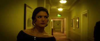 Movie still from “Haywire” (2011), directed by Steven Soderbergh – A woman standing in a hallway looking at the camera; Close Up shot, Low angle