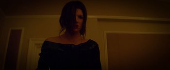 Movie still from “Haywire” (2011), directed by Steven Soderbergh – A woman standing in a dark room wearing a black dress; Medium shot, Low angle