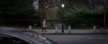 A man walking down a street near a lamp post