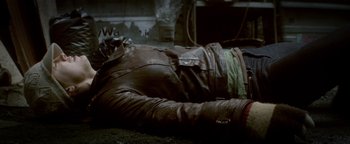 Movie still from “Haywire” (2011), directed by Steven Soderbergh – A man in a leather jacket laying on the ground; Medium shot, Overhead angle