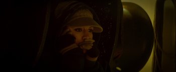 Movie still from “Haywire” (2011), directed by Steven Soderbergh – A woman wearing a hat and gloves in the dark; Close Up shot, High angle