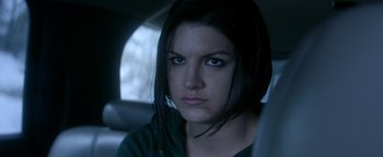 Movie still from “Haywire” (2011), directed by Steven Soderbergh – A person in a car looking at the camera; Close Up shot, Over the shoulder angle