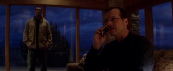 Movie still from “Haywire” (2011), directed by Steven Soderbergh – A man with glasses is talking on a cell phone; Medium shot, Over the shoulder angle