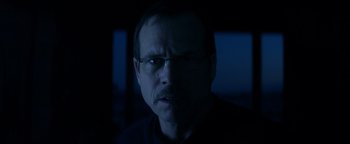 Movie still from “Haywire” (2011), directed by Steven Soderbergh – A person wearing glasses in the dark; Close Up shot, Low angle