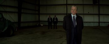 Movie still from “Haywire” (2011), directed by Steven Soderbergh – A man in a suit and tie standing in front of another man in a suit and tie; Medium shot, Low angle