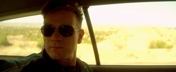 Movie still from “Haywire” (2011), directed by Steven Soderbergh – A person wearing sunglasses in a car; Close Up shot, Over the shoulder angle