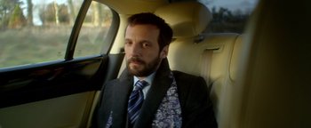 Movie still from “Haywire” (2011), directed by Steven Soderbergh – A man sitting in the back seat of a car; Close Up shot, Over the shoulder angle