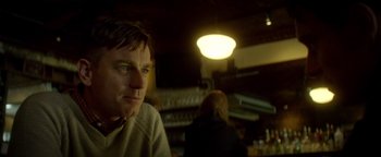 Movie still from “Haywire” (2011), directed by Steven Soderbergh – A person sitting in front of a lamp; Close Up shot, Low angle