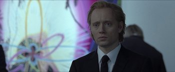 Movie still from “Headhunters” (2011), directed by Morten Tyldum – A person wearing a suit and tie; Close Up shot, Over the shoulder angle