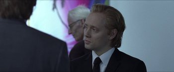 Movie still from “Headhunters” (2011), directed by Morten Tyldum – A person wearing a suit and tie; Close Up shot, Over the shoulder angle