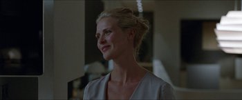 Movie still from “Headhunters” (2011), directed by Morten Tyldum – A woman with blonde hair is smiling at the camera; Close Up shot, Over the shoulder angle