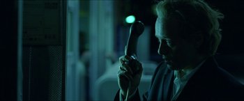 Movie still from “Headhunters” (2011), directed by Morten Tyldum – An older man holding a phone up to his ear; Close Up shot, Low angle